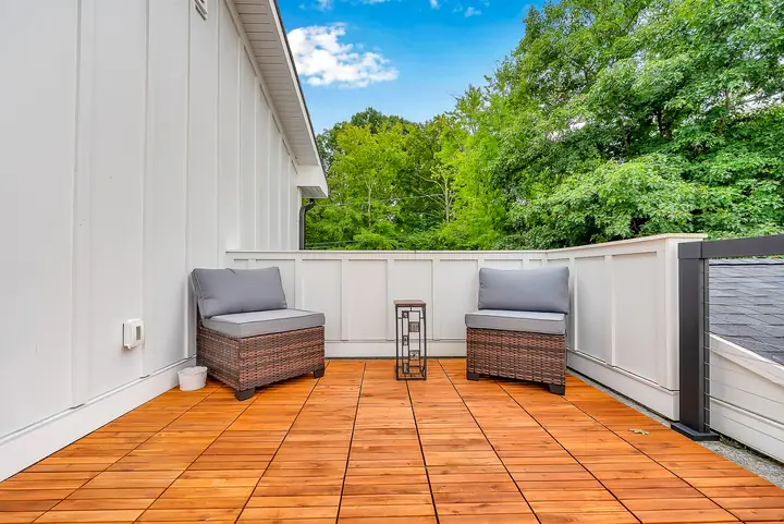 The Blue View's private balcony, a teak floor and two chairs among the trees