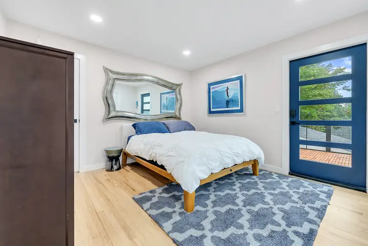 The Blue View's blue glass door onto its own balcony, beside the queen bed