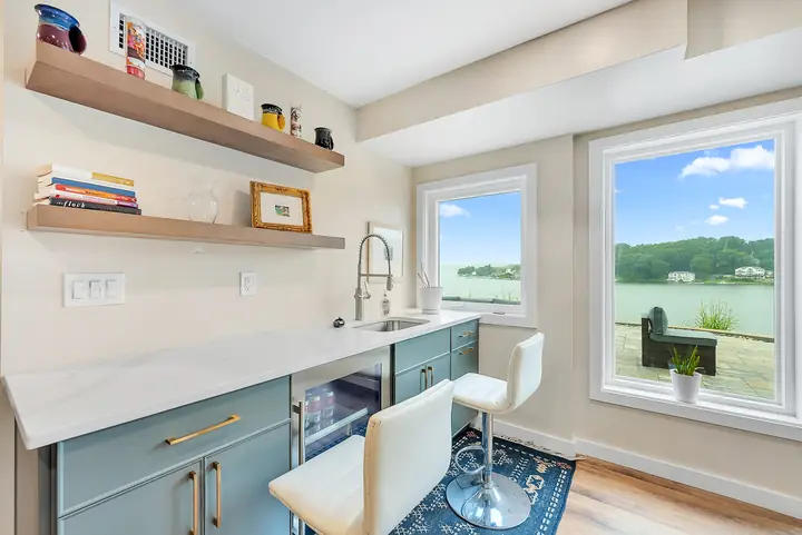 The retreat space's kitchenette, a stone counter and two stools by a window over the lake