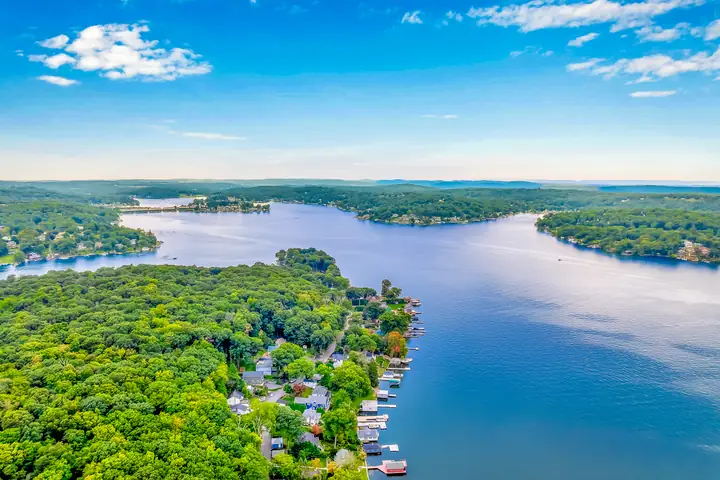 Two arms of the lake meeting around a wooded peninsula, seen from high above