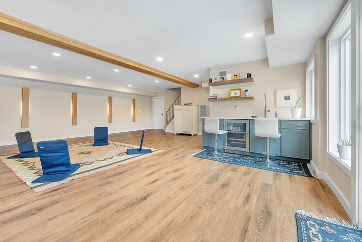 The retreat space from its far end, mats laid out on the floor and the kitchenette counter along the right-hand wall